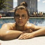 Lucia Caminos relaxing in the pool in the sun with a cocktail nearby in GTA VI.