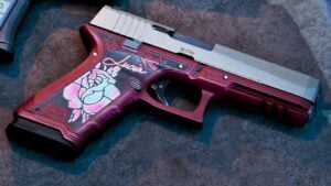 A customized variant of the Klose K17 Pistol in GTA 6, featuring a pink frame, silver slide, and Lucia's name with a flower pattern on the grip.
